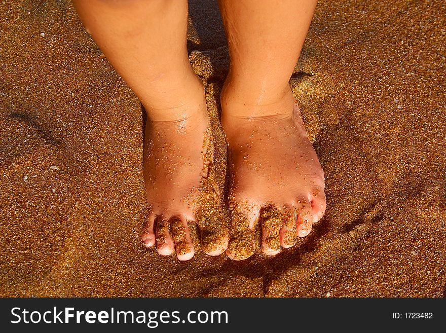 Feet of a little boy in the sand of the bay of San Agustinillo, Oaxaca, Mexico, Latin America. Feet of a little boy in the sand of the bay of San Agustinillo, Oaxaca, Mexico, Latin America