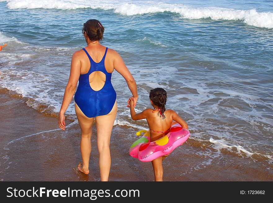 Mother and daughter going to swim at the bay of San Agustinillo in the southern state of Oaxaca in Mexico, Latinamerica. Mother and daughter going to swim at the bay of San Agustinillo in the southern state of Oaxaca in Mexico, Latinamerica