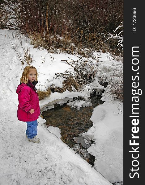 Little girl crossing foot bridge over snow and water. Little girl crossing foot bridge over snow and water