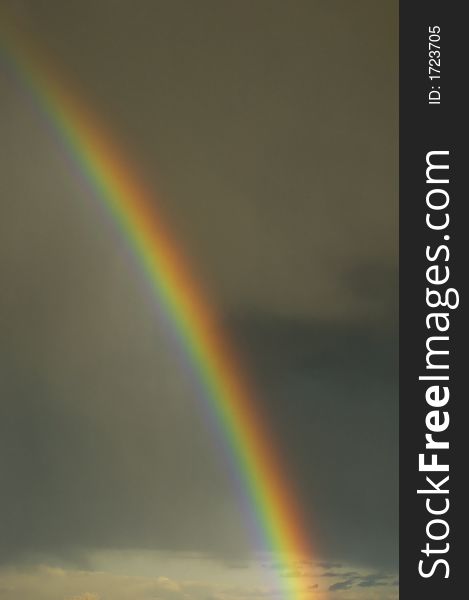 Colorful bright rainbow set against stormy sky. Colorful bright rainbow set against stormy sky