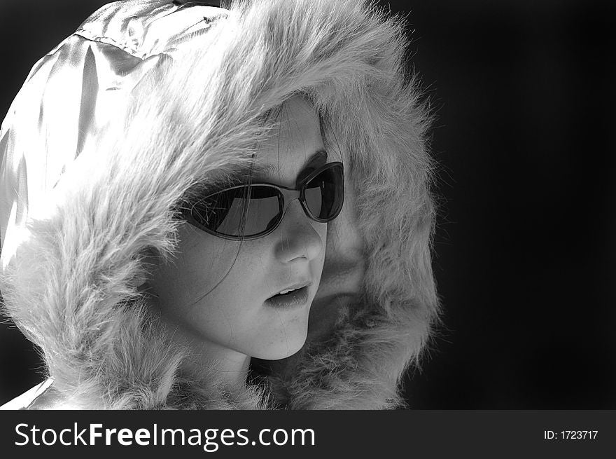 Teen girl wearing sunglasses and winter coat with fur lined hood. Teen girl wearing sunglasses and winter coat with fur lined hood