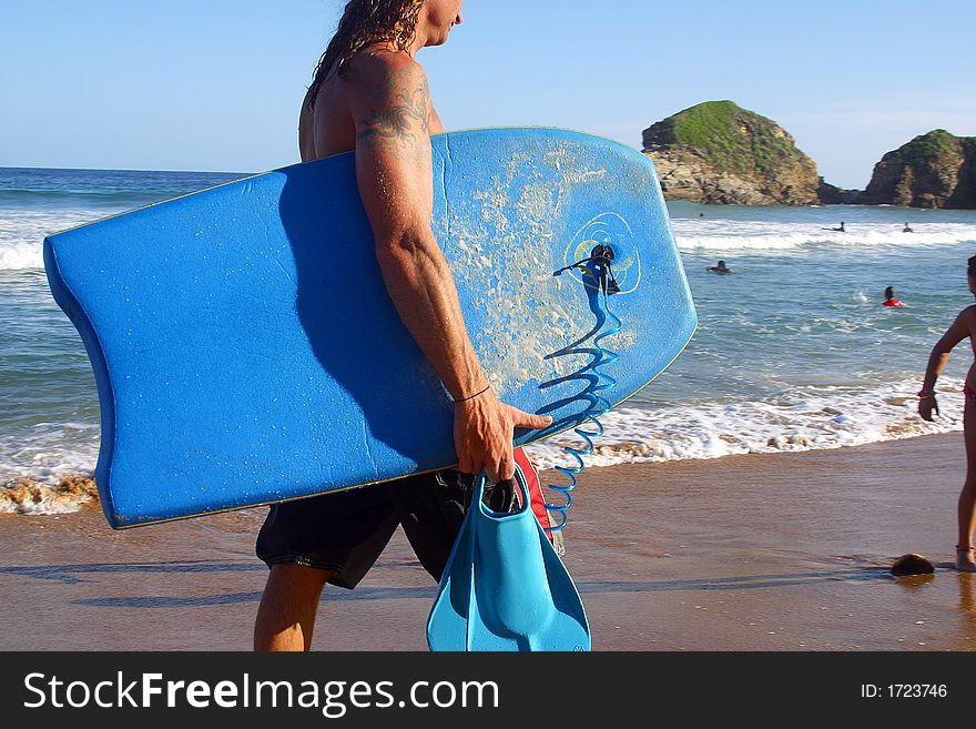 Man carrying his surfboard at the bay of San Agustinillo in the southern state of Oaxaca in Mexico, Latinamerica