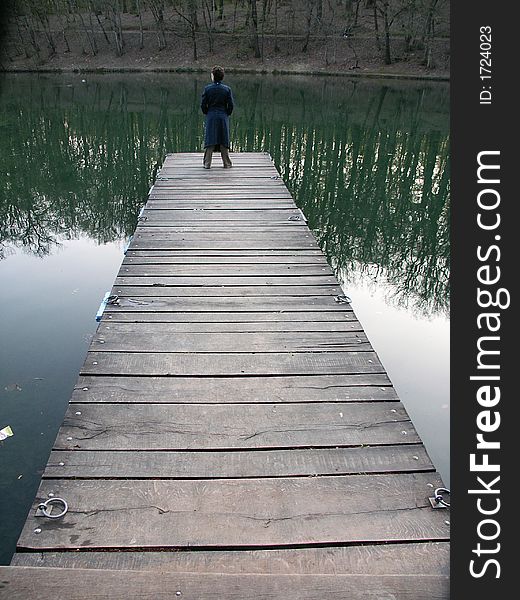 Alone girl on the old wooden mole