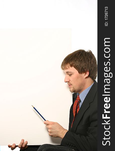 Young man pointing at blank chart over white space in a suit. Young man pointing at blank chart over white space in a suit