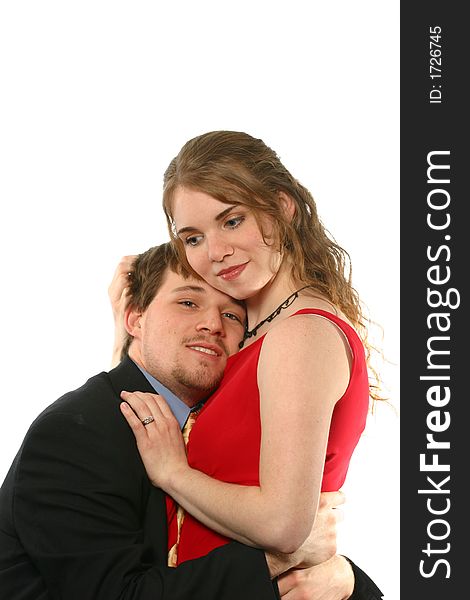 Handsome young man embraces beautiful young lady in a red dress isolated on white space. Handsome young man embraces beautiful young lady in a red dress isolated on white space