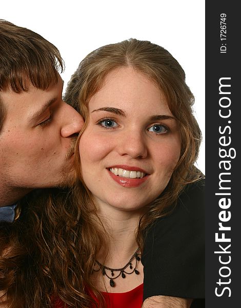 Handsome young man kisses beautiful young lady in a red dress isolated on white space. Handsome young man kisses beautiful young lady in a red dress isolated on white space