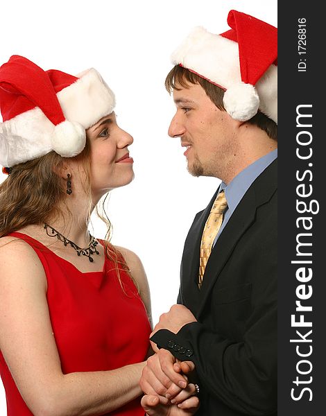 Young smiling couple wearing Santa hats at Christmas. Young smiling couple wearing Santa hats at Christmas