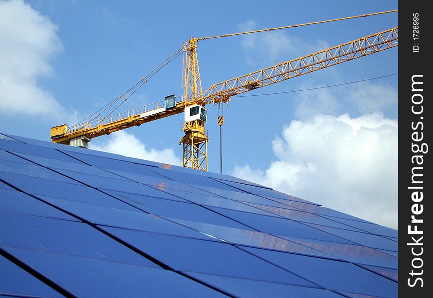 Crane at a construction site and its reflection off of blue tiles. Levels adjusted and logos removed in Photoshop. Crane at a construction site and its reflection off of blue tiles. Levels adjusted and logos removed in Photoshop.