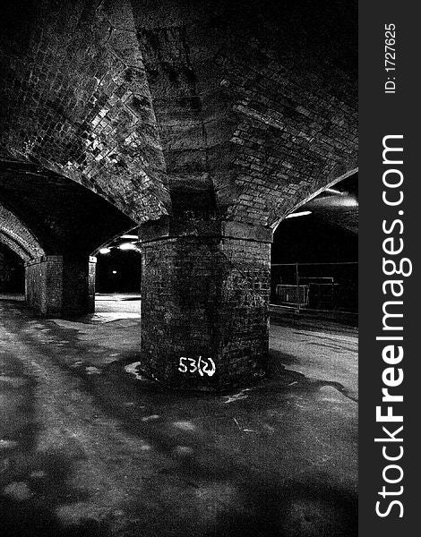 Central arch of old railway viaduct taken in black and white
