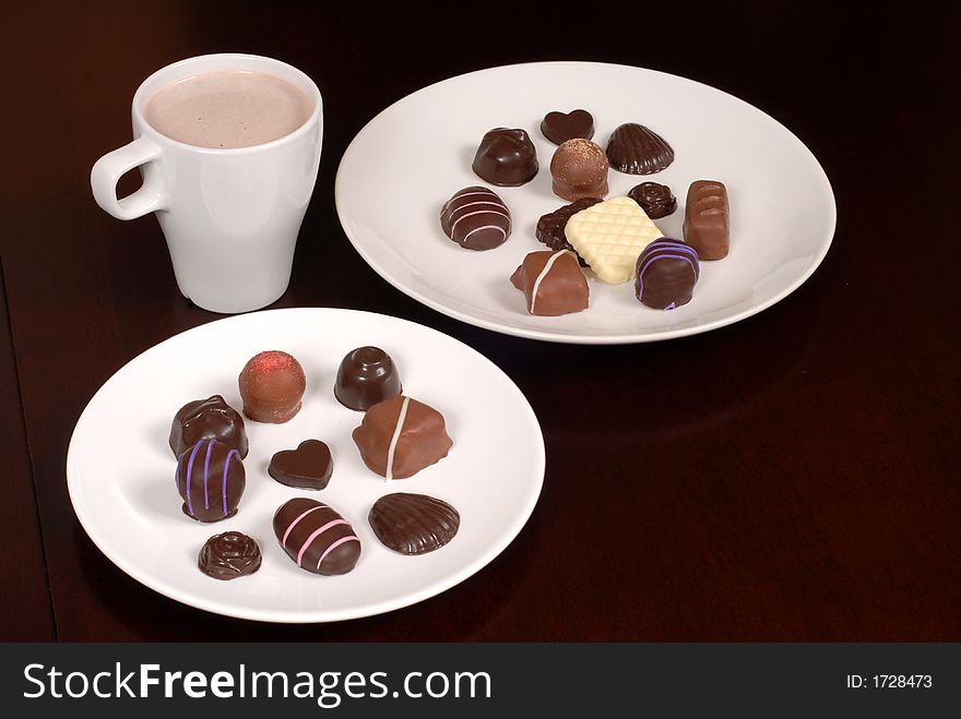 Two plates of delicious chocolates with a cup of hot chocolate. Two plates of delicious chocolates with a cup of hot chocolate