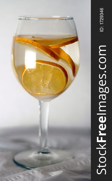 A wine glass shot with slices of tangerine inside. Shot on white background. A wine glass shot with slices of tangerine inside. Shot on white background.