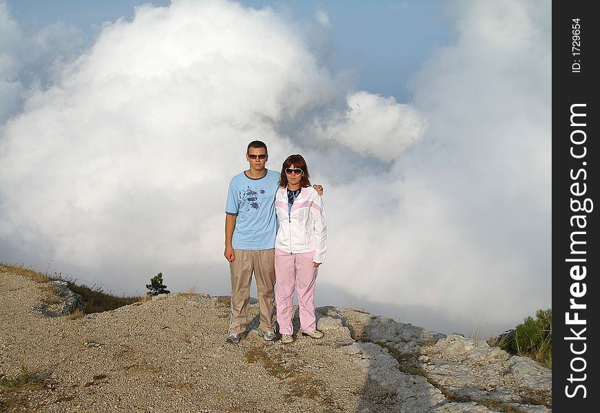 Girl and young person on mountain above cloud