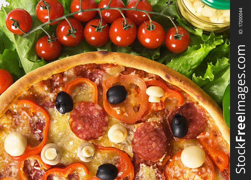 Closeup picture of a pizza with vegetables and cherry tomatoes