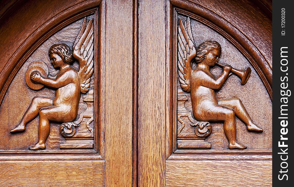 Two angels carved on a wooden door. Two angels carved on a wooden door