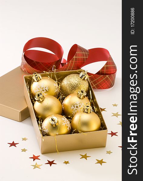Golden Christmas balls in a gift box.White background. Golden Christmas balls in a gift box.White background.