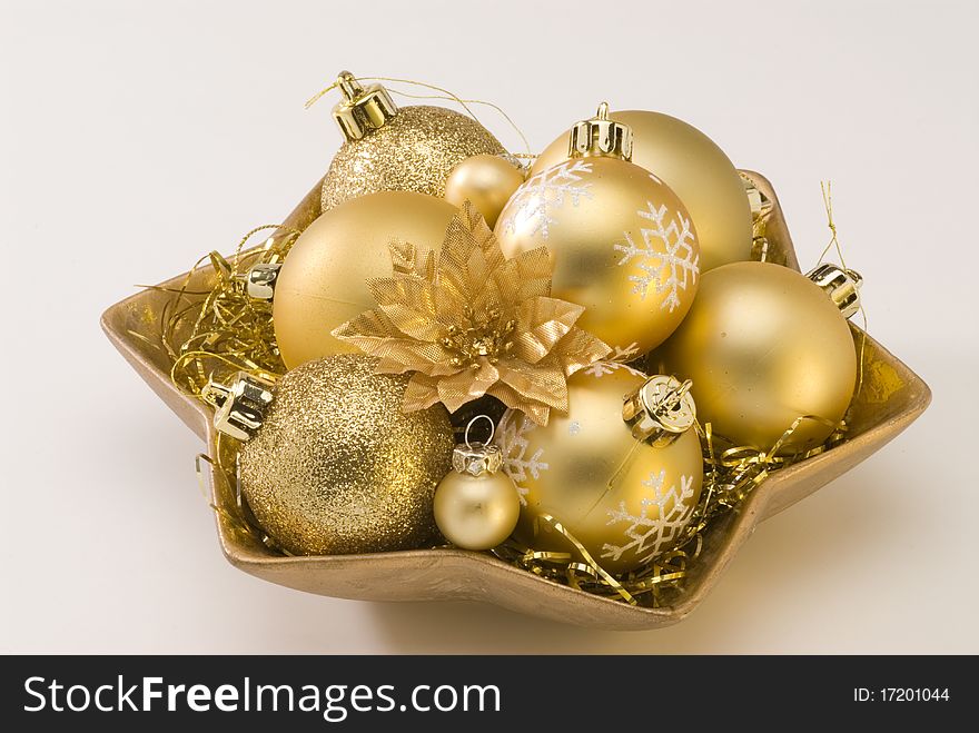 Golden Christmas balls in a plate.White background. Golden Christmas balls in a plate.White background.