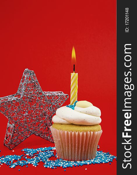 Cupcake With Candle And Star On Red Background