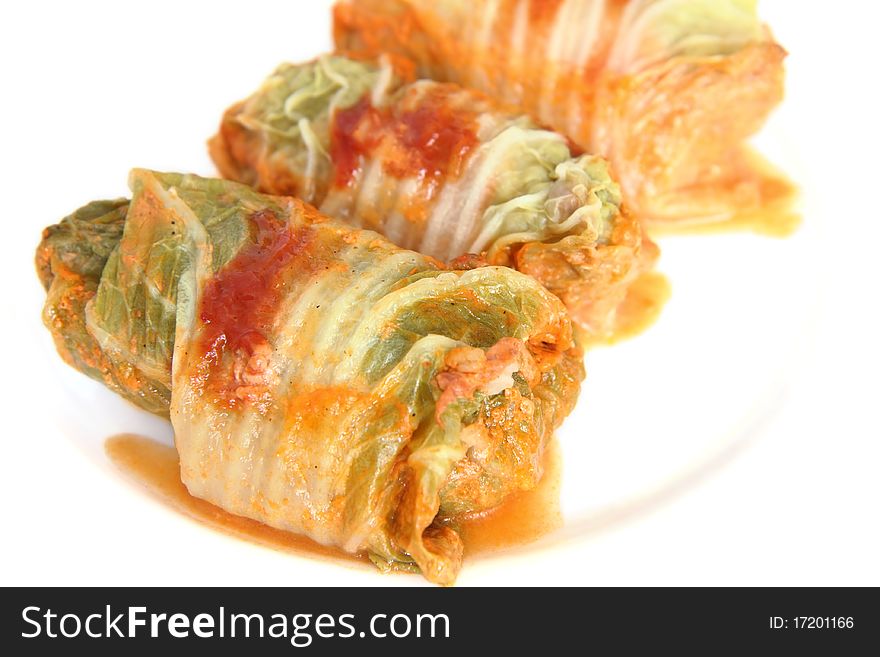 Three stuffed cabbage with spicy tomato sauce on a white plate. Three stuffed cabbage with spicy tomato sauce on a white plate