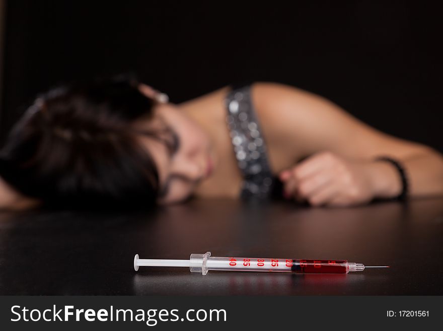 Drug addict woman with is sleeping on table