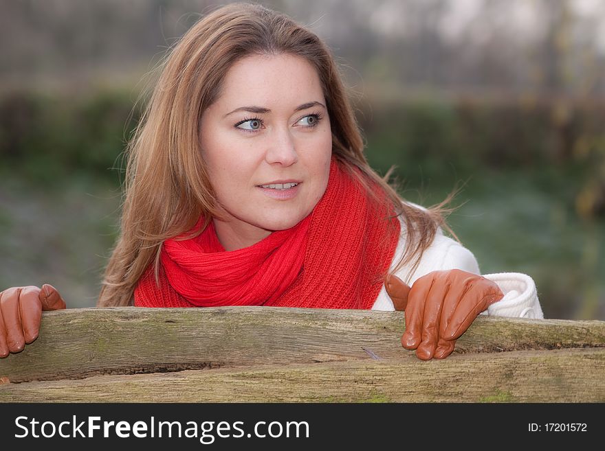 Woman standing by the wooden fence. Woman standing by the wooden fence