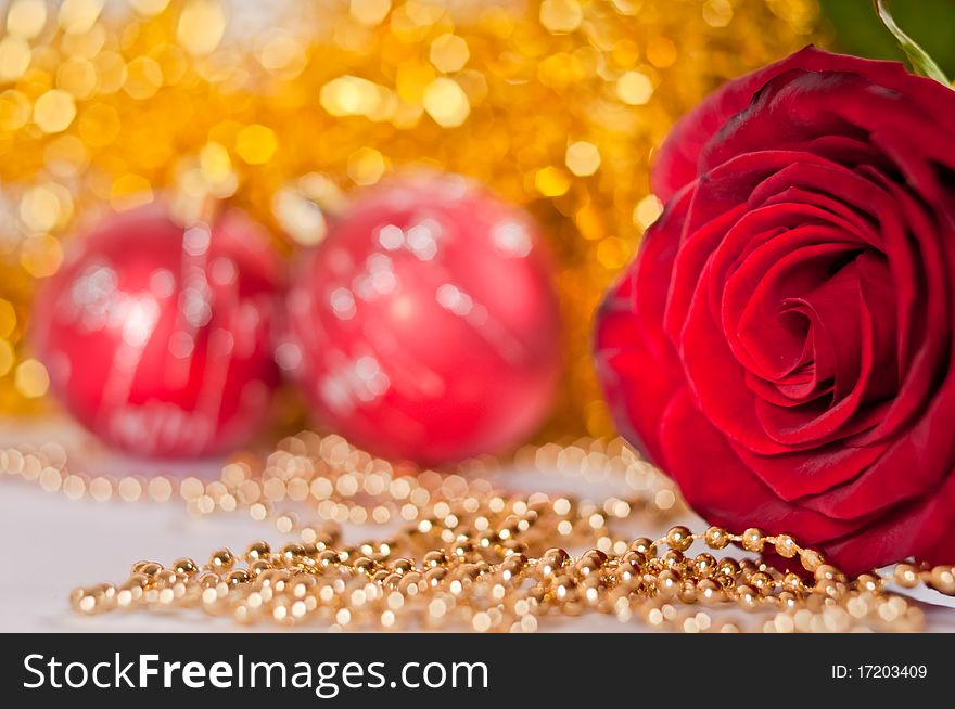 Red rose with christmas balls on background. Red rose with christmas balls on background.