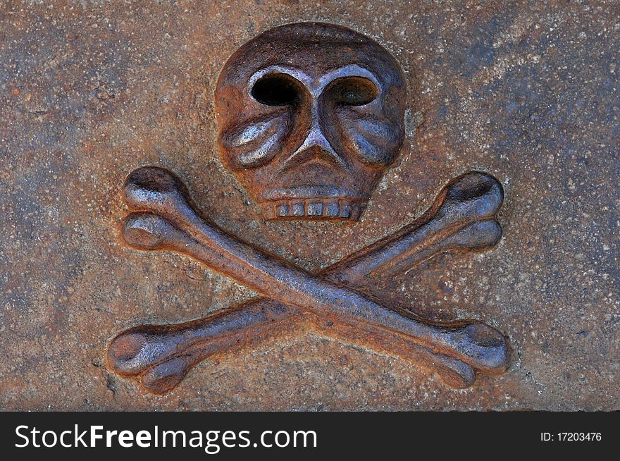 Rusty human skull with crossed bones cast from iron Danger and death symbol. Rusty human skull with crossed bones cast from iron Danger and death symbol
