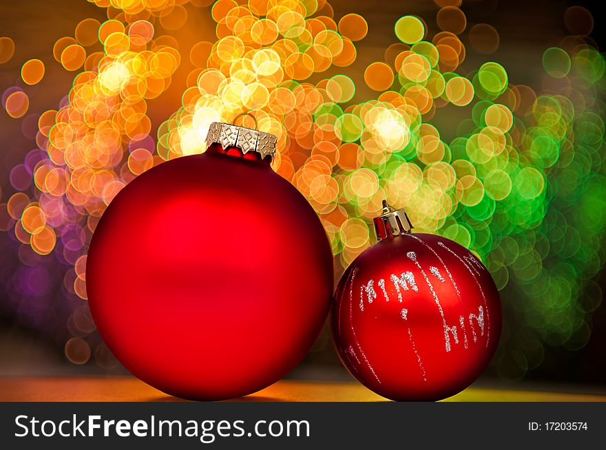 Red Christmas baubles on background of golden lights.