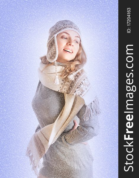 Portrait of a beautiful young woman in winter clothes in the snow