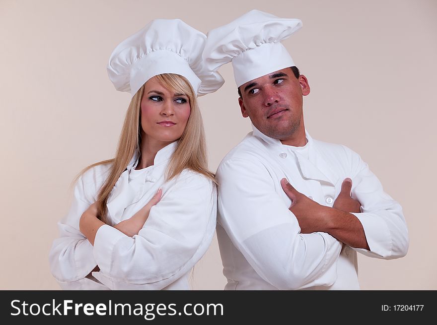 Employee relationship-comp portrait of two expressive uniformed Cooks on a white background. Employee relationship-comp portrait of two expressive uniformed Cooks on a white background