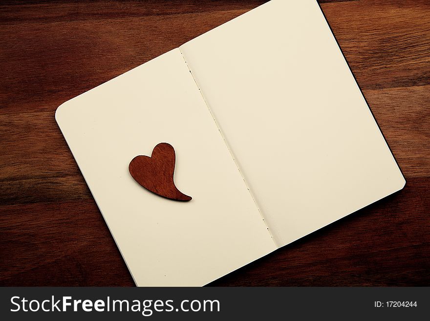 Blank Notebook With Heart On Wooden Background