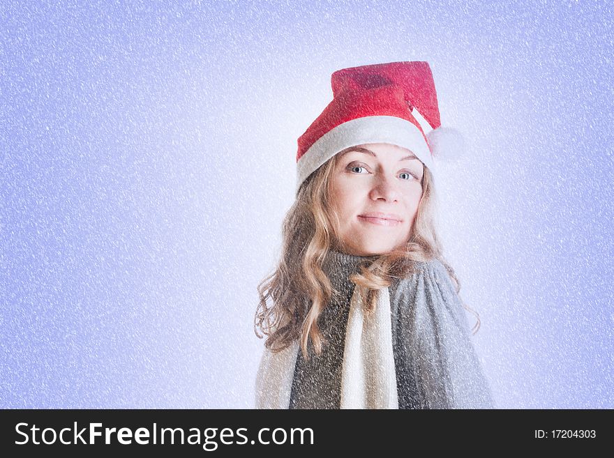 Portrait of a beautiful young woman in Santa hat in the snow