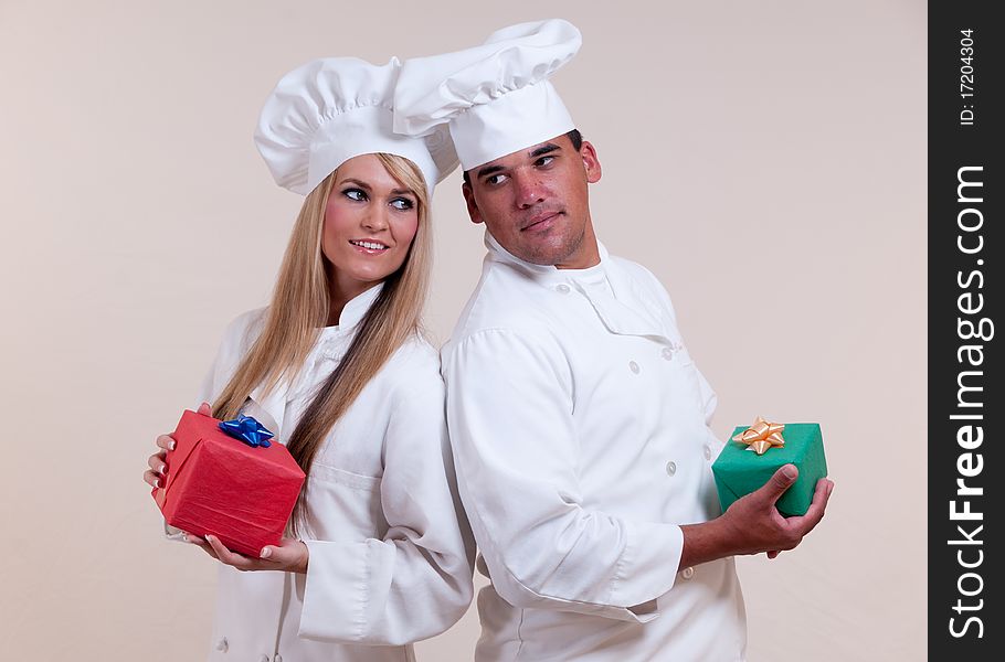 Close up photograph of two uniformed Chefs holding wrapped gifts on a white background. Close up photograph of two uniformed Chefs holding wrapped gifts on a white background