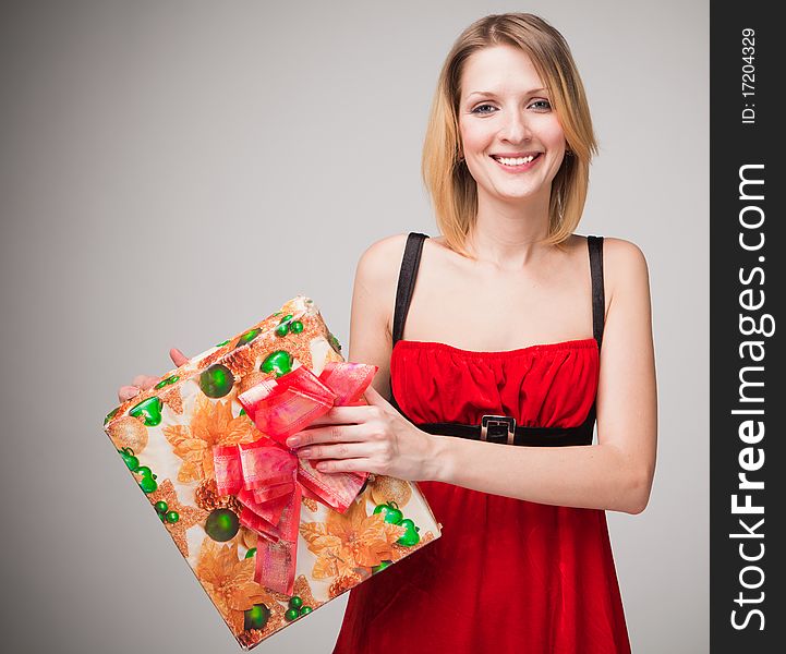 Christmas woman holding gifts on grey background