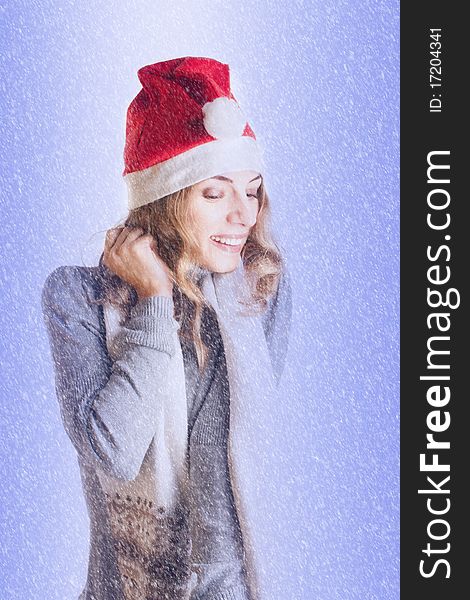 Portrait of a beautiful young woman in Santa hat in the snow (Isolated on white background)