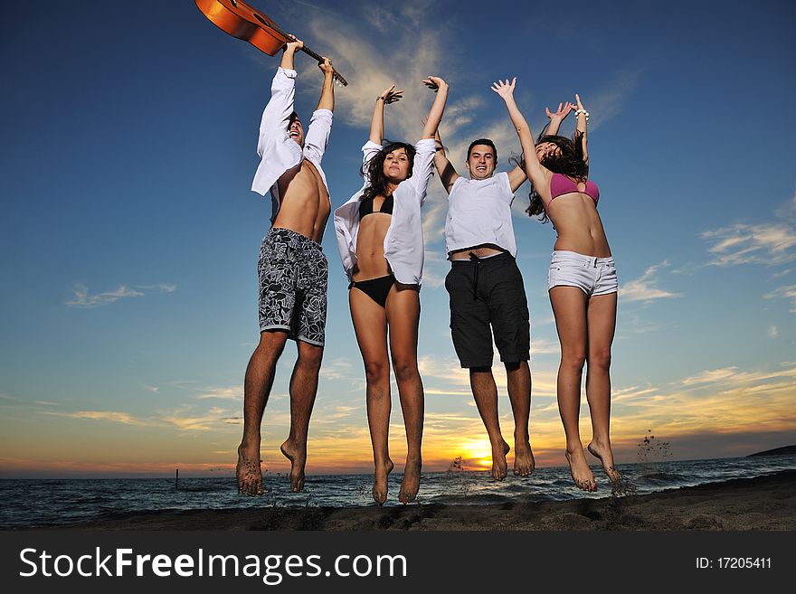 Happy young friends group have fun and celebrate while jumping and running on the beach at the sunset. Happy young friends group have fun and celebrate while jumping and running on the beach at the sunset