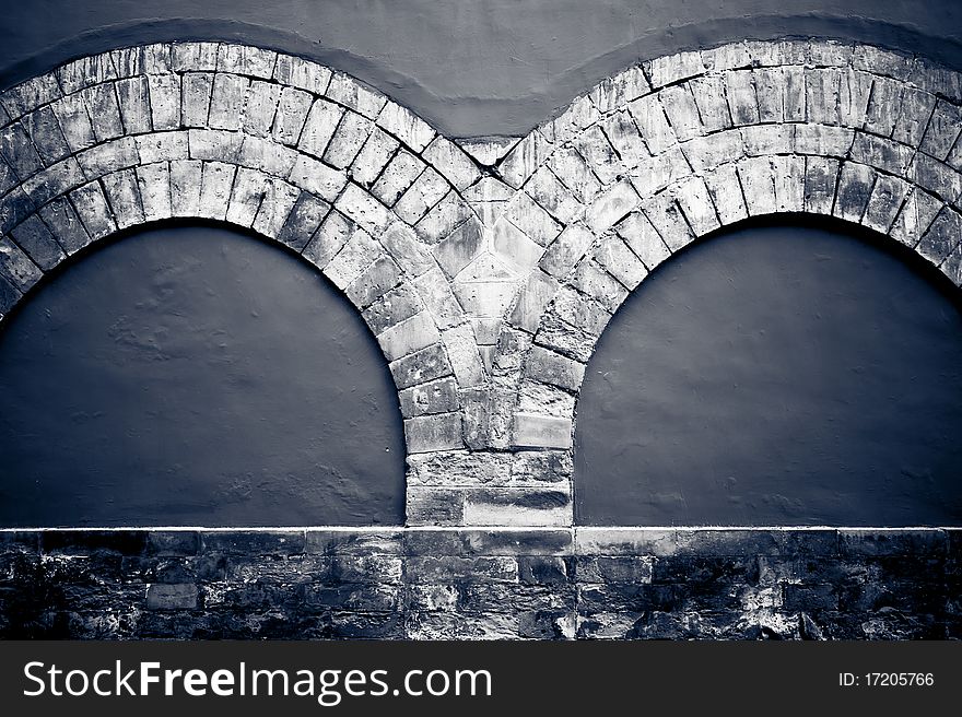 A double stone arch decoration on a wall. A double stone arch decoration on a wall