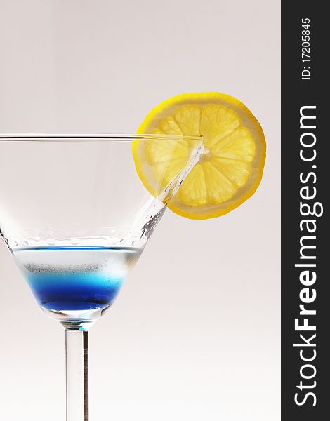 Blue cocktail with yellow lemon closeup