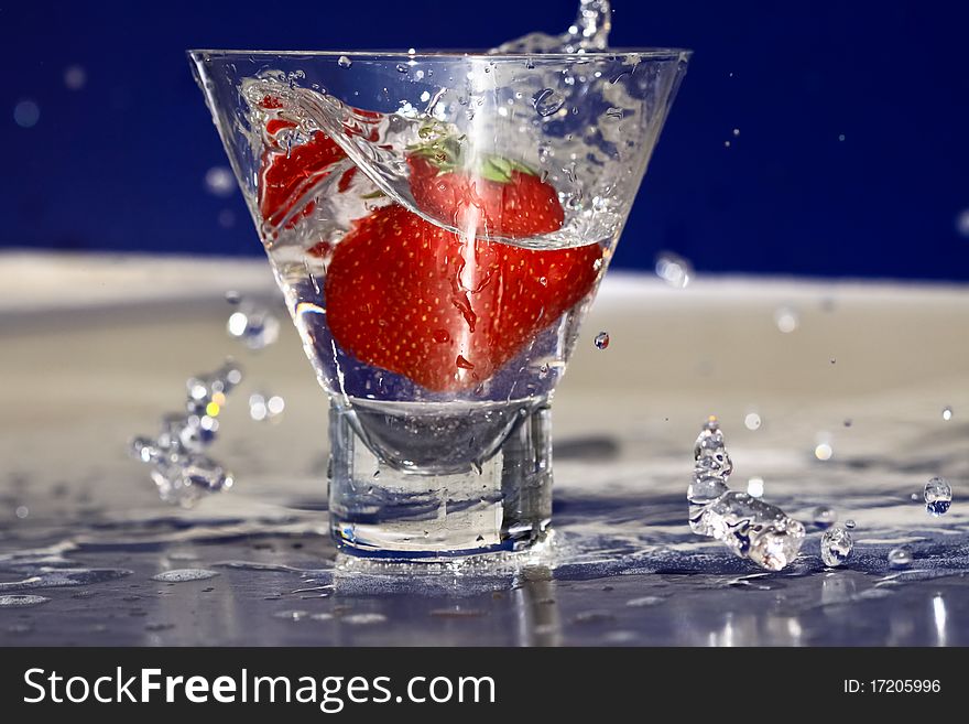 Strawberry drops into a glass of iced water or perhaps lemonade lemonade. Strawberry drops into a glass of iced water or perhaps lemonade lemonade