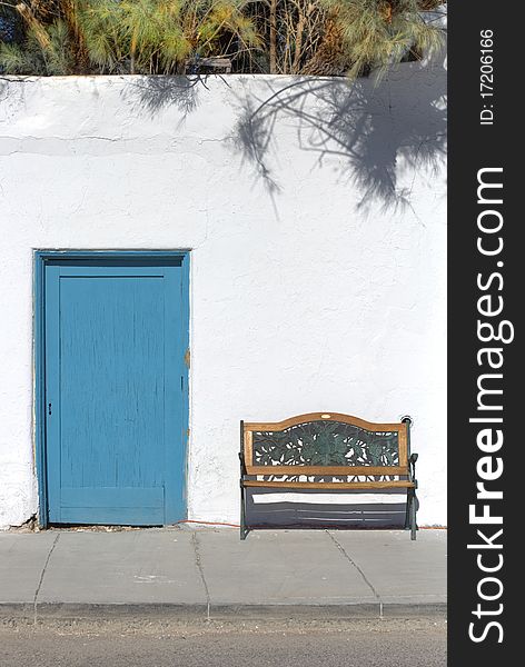 Teal Door and Bench against a Rustic Whitewashed Wall. Teal Door and Bench against a Rustic Whitewashed Wall