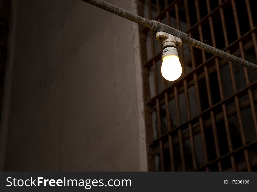 Single light bulb hanging in a prison corridor. Single light bulb hanging in a prison corridor