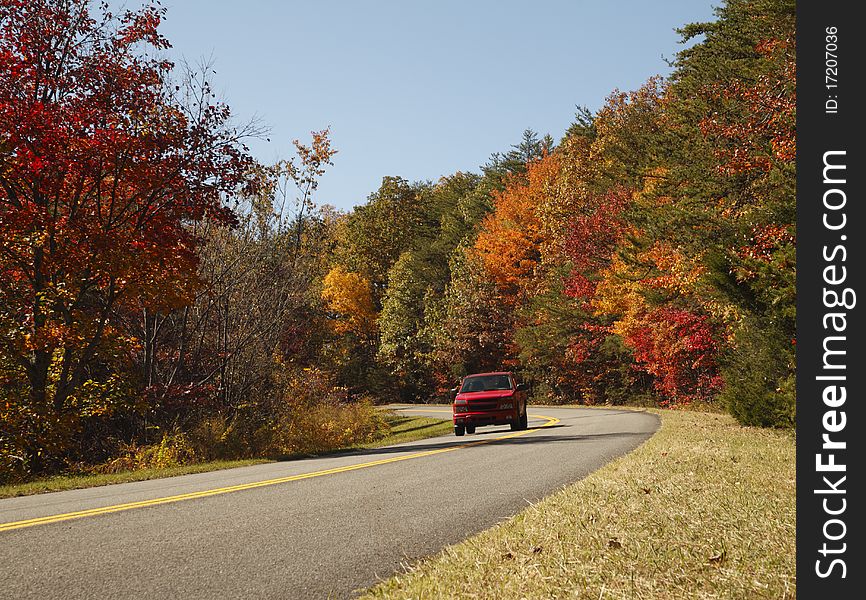 A red truck along a scenic autumn highway of Great Smoky Mountains national Park. A red truck along a scenic autumn highway of Great Smoky Mountains national Park.