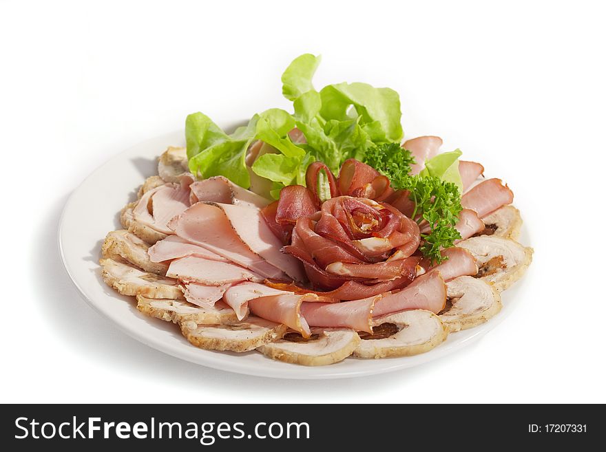 Big group of thinly sliced meat in the form of rose decorated with parsley and dill