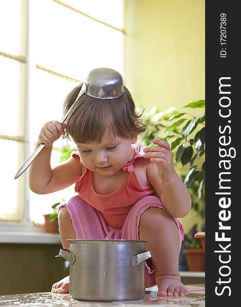 Little Girl With A Pan And Ladle On Her Head