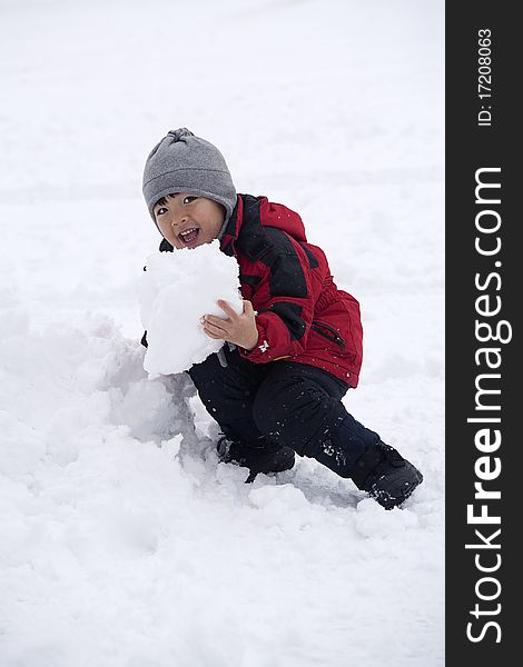 A little boy pretends like he is going to eat a big chunk of snow. A little boy pretends like he is going to eat a big chunk of snow.