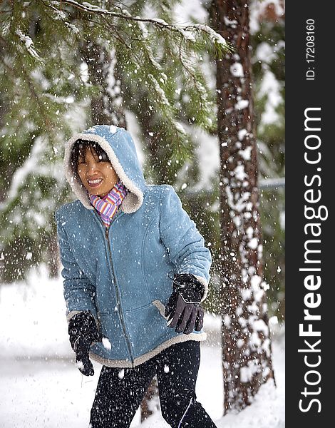Snow from a tree falls down lightly on this Asian woman. Snow from a tree falls down lightly on this Asian woman.