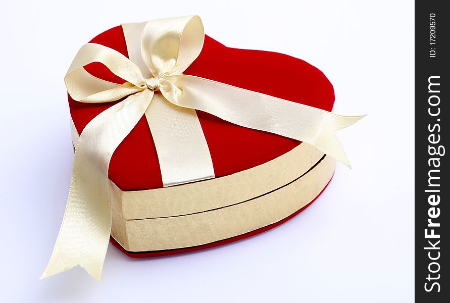With yellow ribbons tied to the red heart-shaped gift box