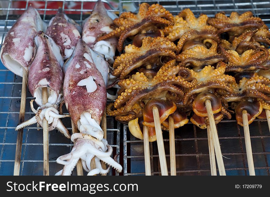 Grilled Squids and octopus heads sold in a Thai market