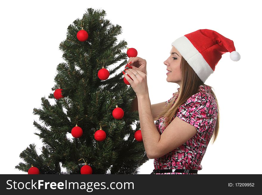 Woman in a christmas hat decorate a christmas tree. Woman in a christmas hat decorate a christmas tree