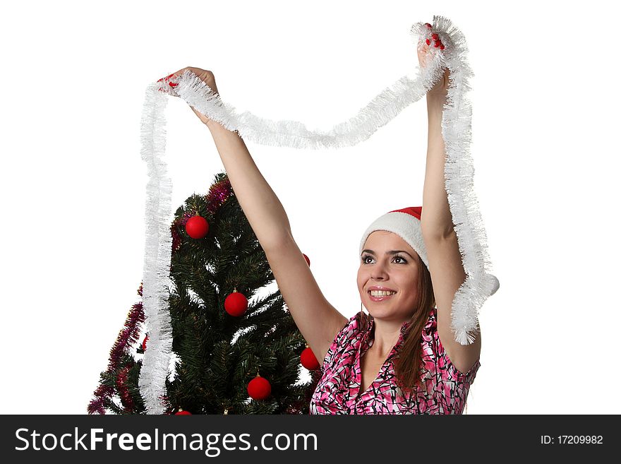 Woman in a Christmas hat decorate a Christmas tree. Woman in a Christmas hat decorate a Christmas tree