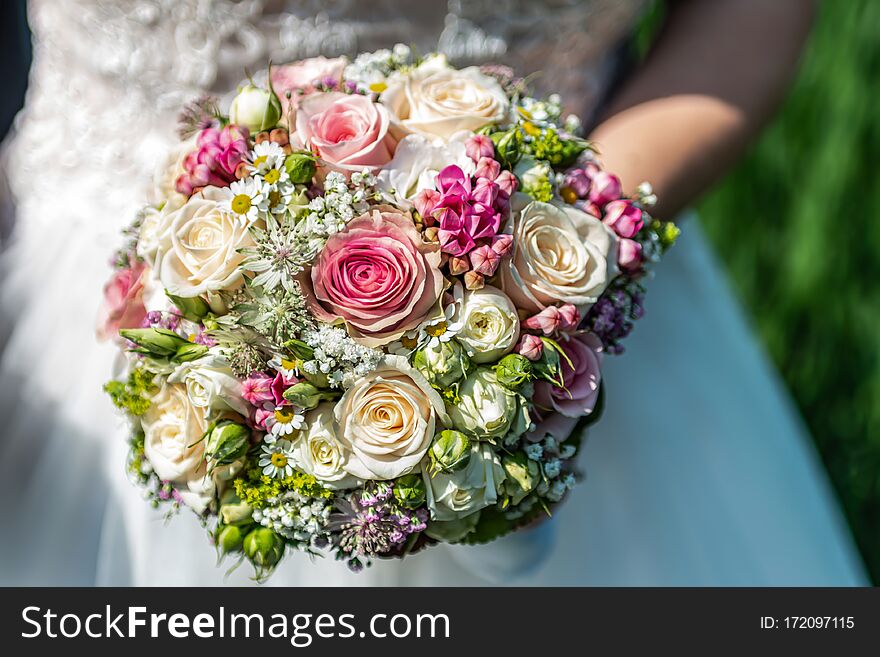 Wedding Bouquet Of Flowers Held By Bride Closeup. Pink And Yellow Roses Flowers